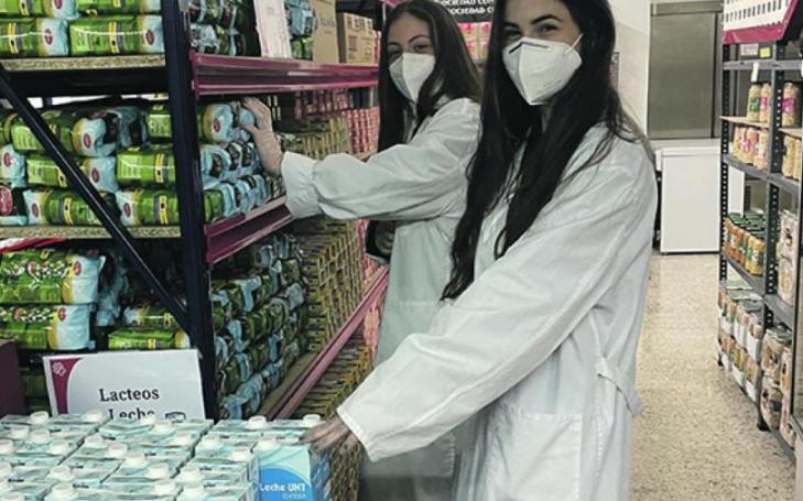 Two BBA students collaborating with Cáritas Diocesana in the San Antón Commissary.
