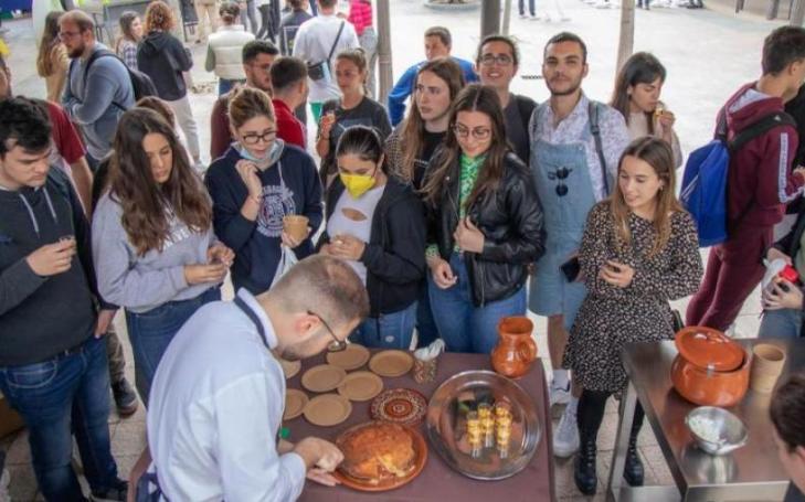 Students of the UCAM Degree in Gastronomy, in the foreground, serving the prepared dishes, while in the background, the fencing and chess tournaments are taking place.