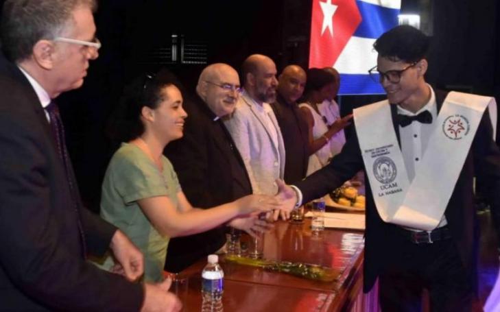 One of the graduating students is congratulated by the members of the Presidential Board.