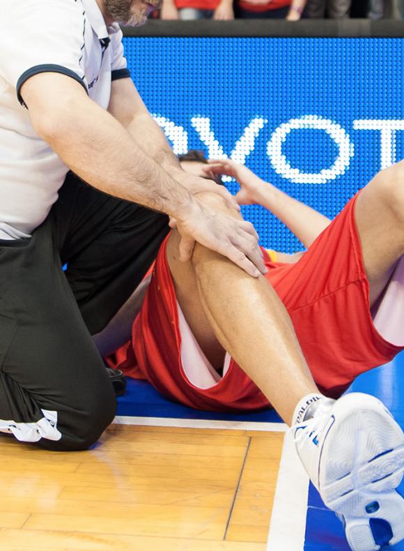 Fisioterapia atendiendo a un jugador de baloncesto
