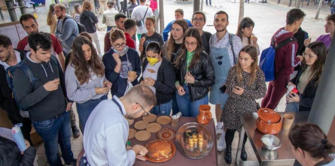 Students of the UCAM Degree in Gastronomy, in the foreground, serving the prepared dishes, while in the background, the fencing and chess tournaments are taking place.