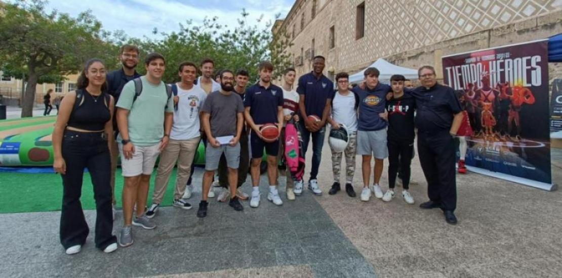 Urban Klavzar and Jordan Sakho, UCAM Murcia CB player, with some UCAM students and Luis Emilio Pascual, chaplain of the University and the basketball club