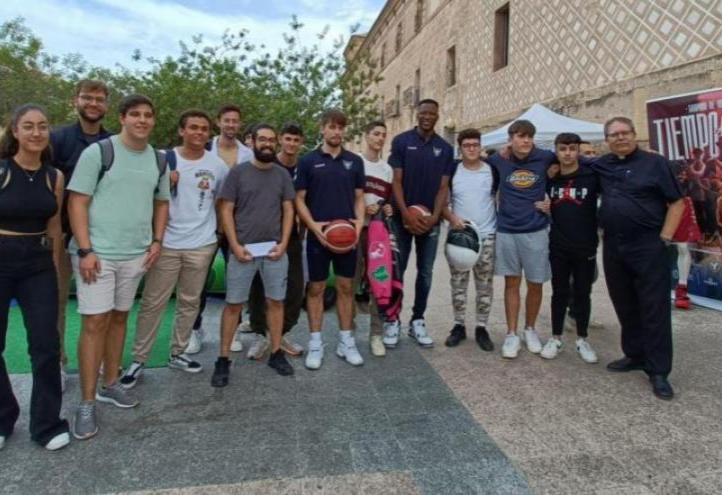 Urban Klavzar and Jordan Sakho, UCAM Murcia CB player, with some UCAM students and Luis Emilio Pascual, chaplain of the University and the basketball club