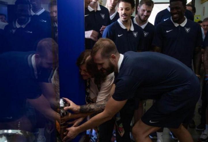 María Dolores García, president of UCAM and UCAM Murcia CB, and Nemanja Radovic, captain of the team, place the cup in the UCAM trophy cabinet