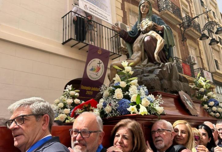 María Dolores García, UCAM president, honours the Virgen de la Piedad as a porter, together with a delegation from the university.
